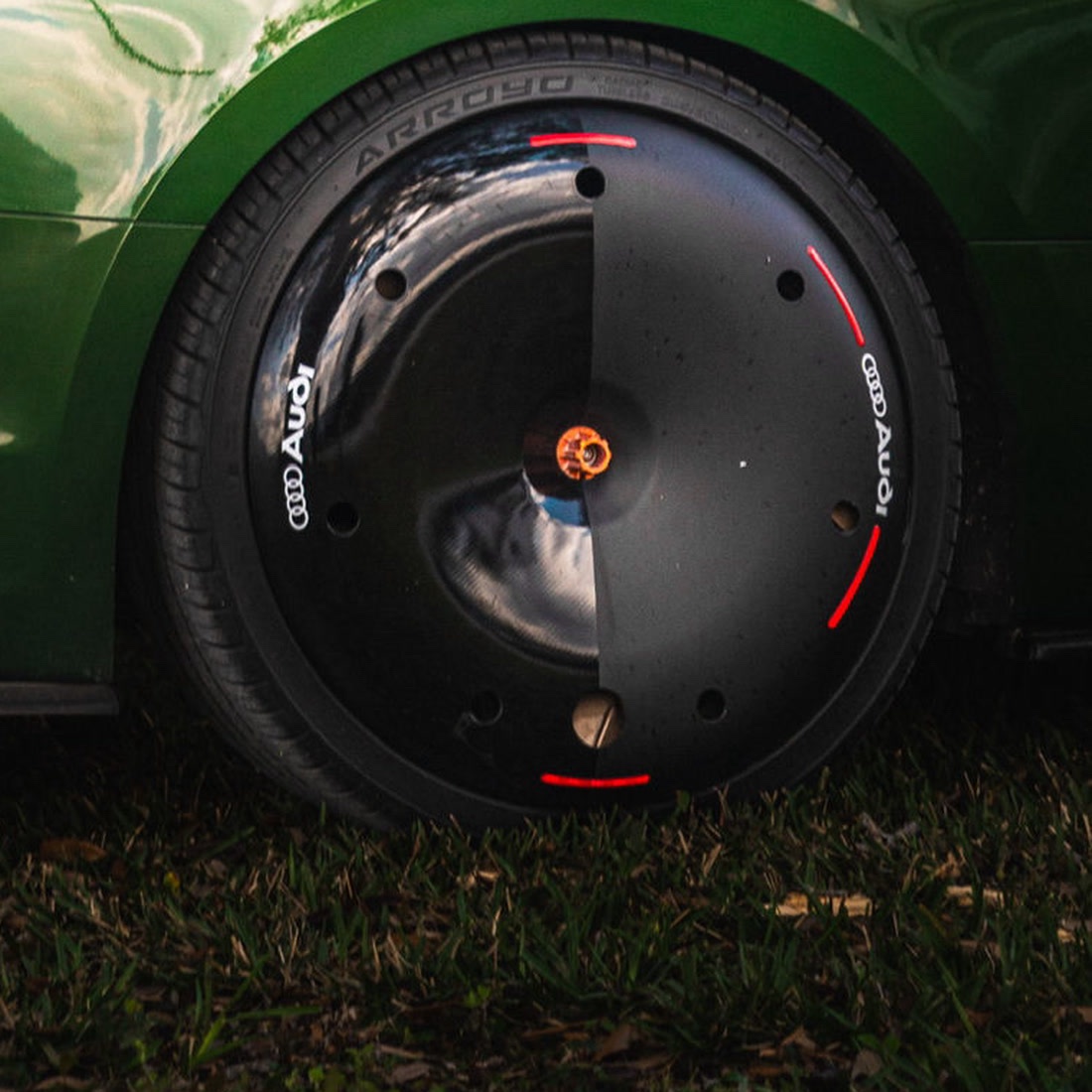 Close detail of a custom AIRODISC on an Audi RS5 with Audi lettering, red accent arcs and a copper anodised centre nut